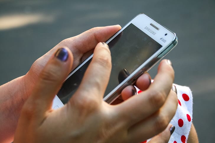 Hand holding a Samsung phone while troubleshooting eSIM settings
