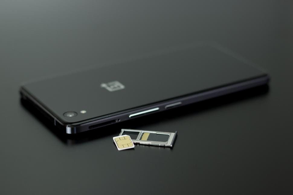 OnePlus smartphone next to a SIM card representing device compatibility